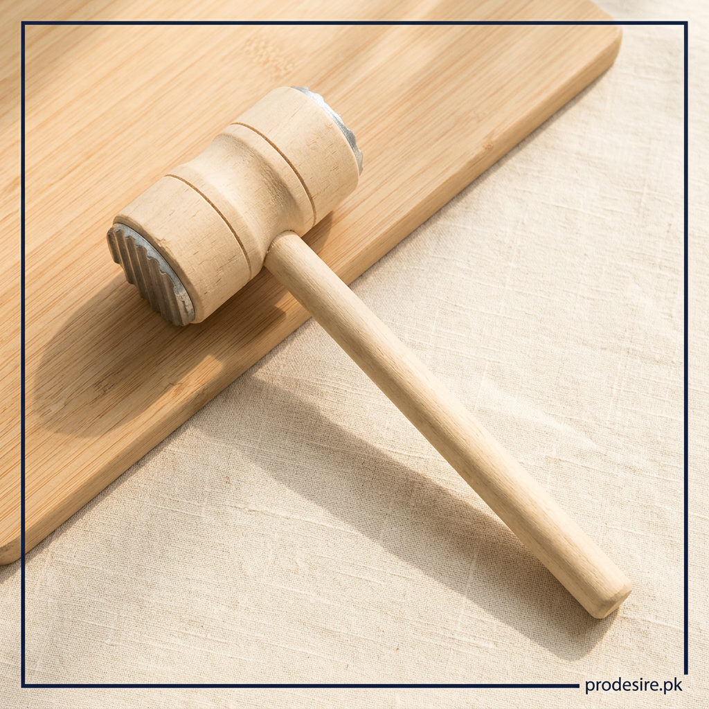 Overhead view of wooden meat hammer beside a cutting board on cream linen